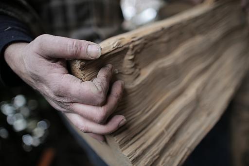 Le luthier italien Roberto Ceretti porte une pièce de bois dans son atelier pour en faire une guitare, à Barge, près de Turin, le 22 janvier 2015 © Marco Bertorello AFP