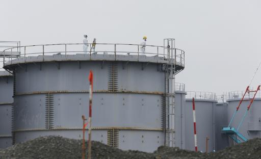 Des employes travaillent sur une citerne contenant de l'eau contaminee a la centrale nucleaire de Fukushima Daiichi au Japon, le 12 novembre 2014