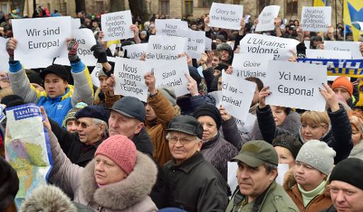 Des Ukrainiens participant à la "Marche de la dignité" en souvenir des manifestants morts il y a un an sur la place Maïdan portent des pancartes où l'on peut lire: "Gloire à nos héros!", "Nous sommes l'Europe", le 22 février 2015 à Kiev © Sergei Soupinski AFP