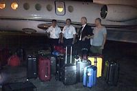Les Francais Nicolas Pisapia, Alain Castany, Bruno Odos et Pascal Fauret pris en photo devant les valises de cocaine dans une mise en scene grotesque.