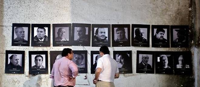 Des membres de l'association des Anciens Prisonniers Politiques du Stade National regardent des photos de la periode de la dictature de Pinochet exposees dans le stade, le 10 fevrier 2015 a Santiago