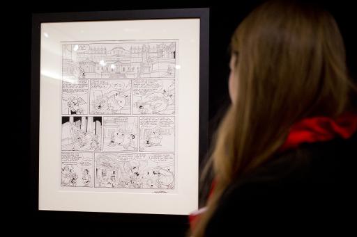 Une personne regarde une planche originale de l'album d'Asterix "Les Lauriers de Cesar" vendue par Christie's, le 14 mars 2015 a Paris