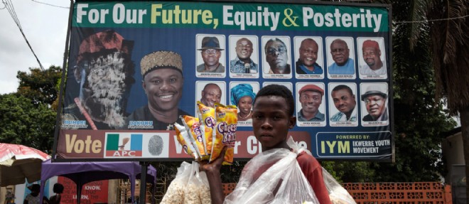 Un petit vendeur de pop-corn devant les affiches electorales de Muhammadu Buhari, qui se presente face a Goodluck Jonathan lors de ces elections.
