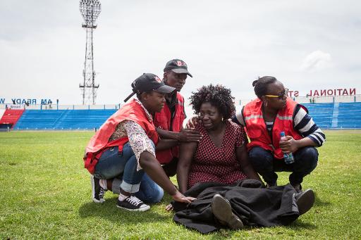 Dans le stade Nyayo à Nairobi le 5 avril 2015, des membres de la Croix Rouge aident une femme bouleversée après avoir appris qu'un de ses proches était mort dans l'attaque des shebab © Nichole Sobecki AFP