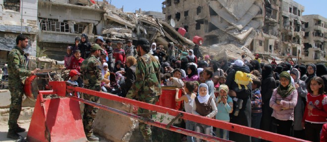 Des femmes et des enfants fuient la camp de Yarmouk, dans la banlieue de Damas.