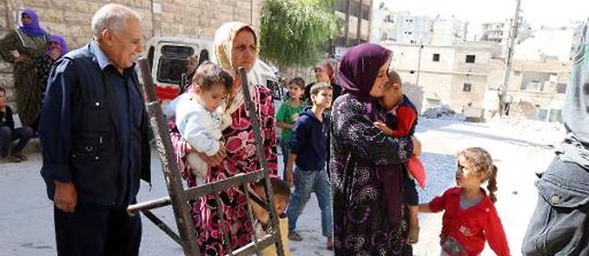 Des refugies kurdes attendent la distribution d'assistance humanitaire le 23 septembre 2014 a Alep, dans le nord de la Syrie