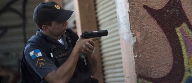 Un policier bresilien patrouille dans la favela d'Alemao, a Rio de Janeiro, le 3 avril 2015.
