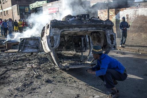 Une voiture brûlée après des violences xénophobes dans le quartier de Jeppestown, à Johannesburg, le 17 avril 2015 © Mujahid Safodien AFP