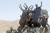 Le 8 août 2014, des soldats libanais font le signe de la victoire en arrivant à Ersal, une ville du nord située à la frontière syrienne. ©Bilal Jawich / ANADOLU AGENCY