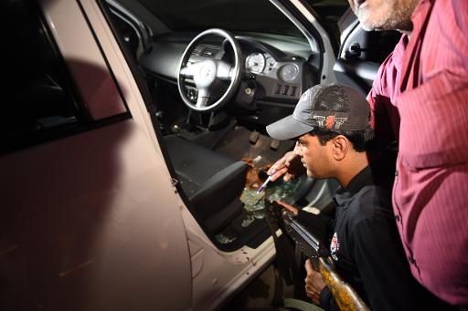 Un officier de police pakistanais mene des investigations dans la voiture dans laquelle a ete abattue Sabeen Mahmud, militante des droits de l'Homme, a Karachi le 24 avril 2015