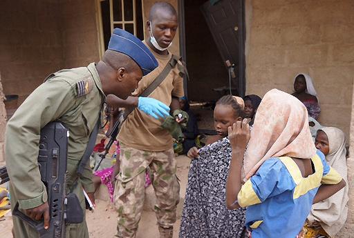 Photo fournie par l'armee nigeriane le 30 avril 2015 prise dans un lieu non divulgue de l'Etat de Borno montrant un militaire discutant avec des jeunes filles liberees lors d'une operation contre le groupe islamiste Boko Haram