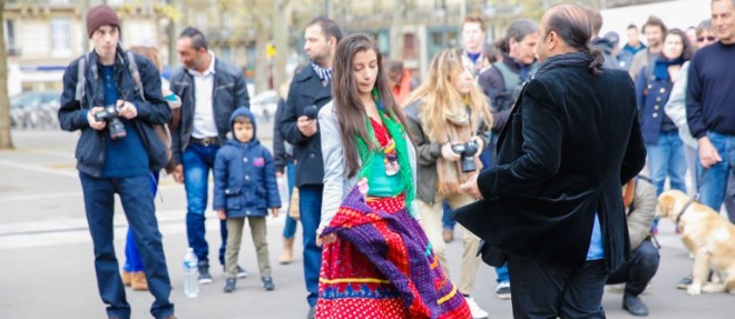 Une femme et un homme issus de la communaute rom dansent dans les rues de Paris a l'occasion d'un concert de defense de cette communaute, le 11 avril 2015 a Paris.