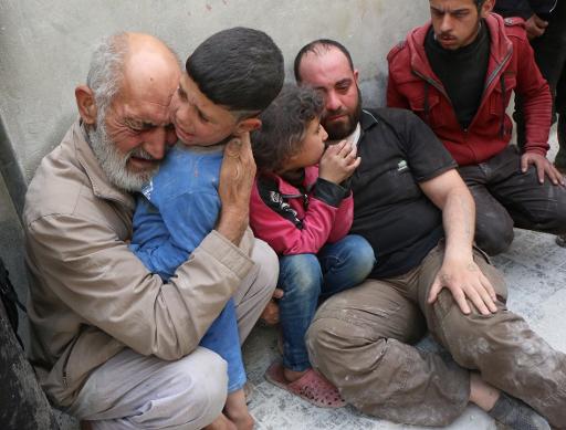 Des familles syriennes lors d'un bombardement des forces du regime le 29 avril sur Alep