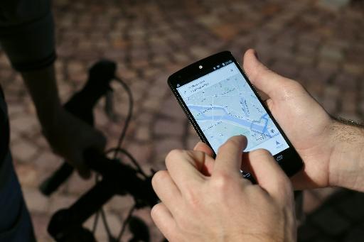 Un homme utilise l'application GPS sur son smartphone à Paris le 4 novembre 2014 © Thomas Samson AFP/Archives
