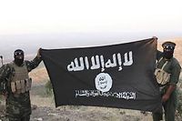 Des combattants du groupe État islamique à Alep en Syrie, en octobre 2013, brandissent le drapeau des djihadistes.  ©Medyan Dairieh