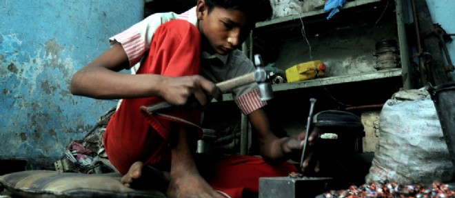 Un mineur essaie d'extraire du cuivre a main nue, a New Delhi en Inde.