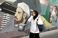 Une jeune femme telephone devant une peinture murale commemorant la guerre Iran-Irak. Sur son nez, un bandage. Signe et symbole manifestes qu'elle a subi une operation de chirurgie esthetique. (C)ALFRED