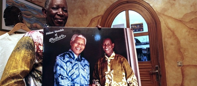 Decembre 2013. Pathe O pose avec une photo dans laquelle il serre la main de Nelson Mandela, l'ex-president sud-africain.