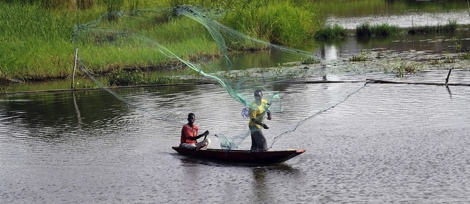 Des pecheurs sur une pirogue sur la lagune Ebrie qui borde Abidjan.