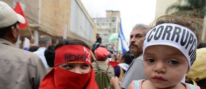 Un enfant porte un bandeau denoncant la corruption, lors d'une manifestation a Tegucigalpa le 3 juin 2015 pour reclamer la demission du president hondurien Juan Orlando Hernandez