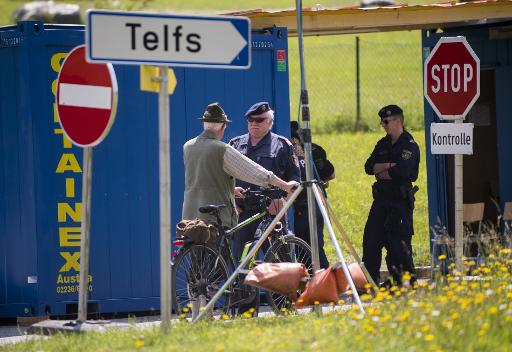 Un homme discute avec un policier a un point de controle sur la route menant a l'hotel ou se reunit le groupe Bilderberg, , en Autriche, le 11 juin 2015