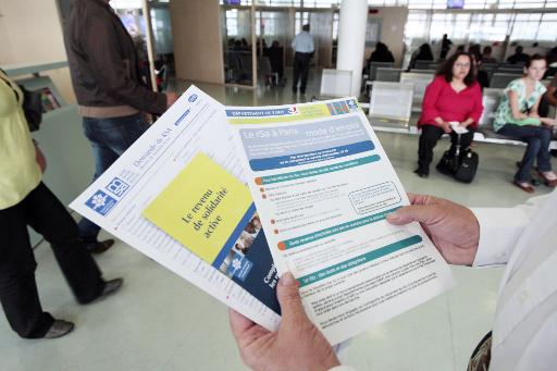 Une personne presente les brochures d'information sur le RSA mises a la disposition des usagers dans un centre de la CAF a Paris le 4 juin 2009