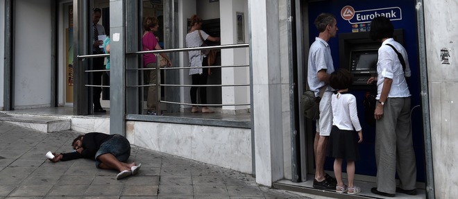 Des gens retirent leur argent sur les distributeurs du centre d'Athenes.