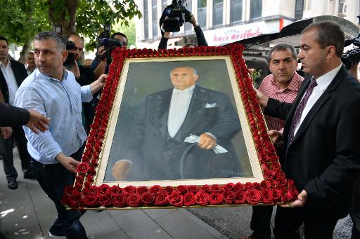 Des gens transportent le portrait de l'ancien president et chef de gouvernement turc, Suleyman Demirel, a Ankara, le 17 juin 2015