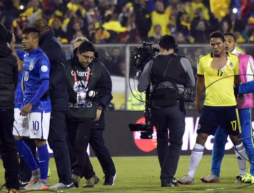 Neymar accompagne par un officiel bresilien apres son altercation avec le Colombien Carlos Bacca (N.17), au stade Monumental de Santiago, le  17 juin 2015