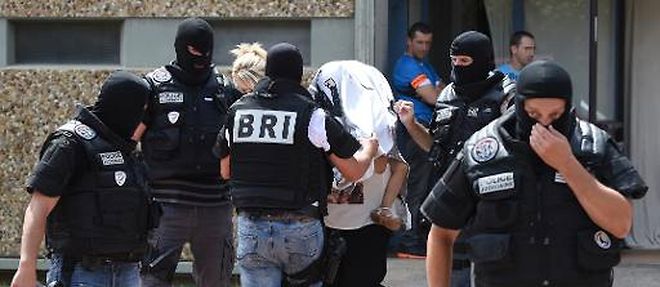 Les forces speciales de la BRI escortent une femme et un enfant dans les bras, le 26 juin 2015 dans la ville de Saint-Priest, pres de Lyon