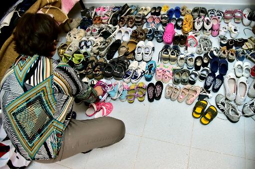 Une bénévole range des chaussures données au centre d'accueil de réfugiés à Carbonia, en Sardaigne, le 16 juin 2015 © GIUSEPPE CACACE AFP