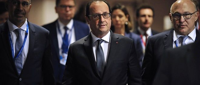 Francois Hollande, flanque du ministre des Finances Michel Sapin et du secretaire d'Etat aux Affaires europeennes Harlem Desir, s'apprete a tenir une conference de presse a l'issue de 17 heures de negociations a Bruxelles.