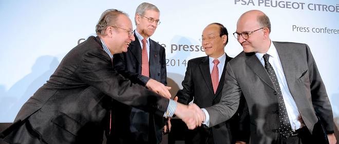 A gauche, Robert Peugeot serre la main de Pierre Moscovici, le 26 mars 2014.