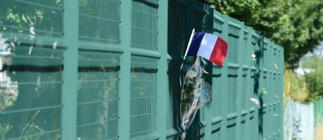 Un drapeau et des fleurs deposes le 28 juin 2015 a l'endroit ou a ete placee la tete de l'homme decapite a Saint-Quentin-Fallavier