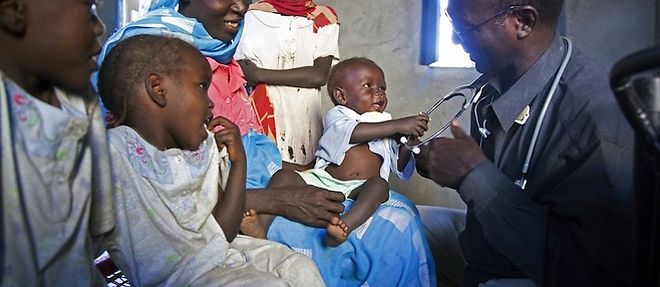 Un medecin examinant des enfants soudanais, au camp de deplaces de Kalma a Nyala, au Darfour, le 6 decembre 2010.