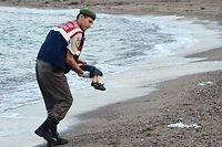 Un policier porte le corps d'Aylan Kurdi retrouvé mort sur la plage de Bodrum, en Turquie. Son frère âgé de 5 ans et sa mère seraient morts noyés eux aussi en tentant de rejoindre Kos en Grèce. Ils venaient de Kobane. ©STR