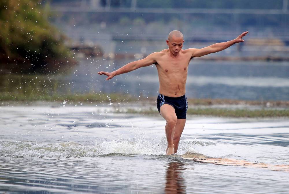 Le moine shaolin Shi Liliang a réussi l'exploit de courir 125 mètres sur l'eau, battant ainsi son record personnel. 
  © Fu dongfeng AFP