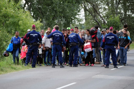 Des policiers hongrois stoppent un groupe de migrants près de Röszke, à la frontière avec la Serbie, le 9 septembre 2015 © CSABA SEGESVARI AFP