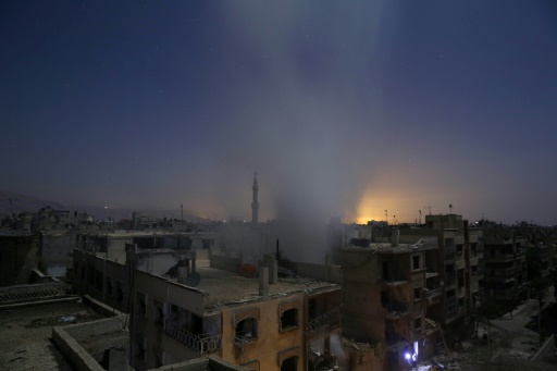 De la fumee s'eleve au-dessus des immeubles de la ville de Douma, cible de tirs de roquettes de l'armee syrienne, le 30 octobre 2015