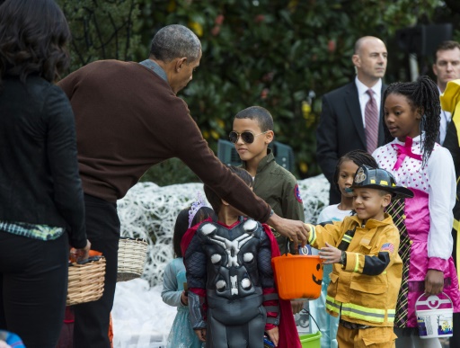 Le président Barack Obama et son épouse Michelle distribuent des bonbons aux enfants lors de la réception annuelle d'Halloween à la Maison Blanche, le 30 octobre 2015 à Washington © SAUL LOEB AFP
