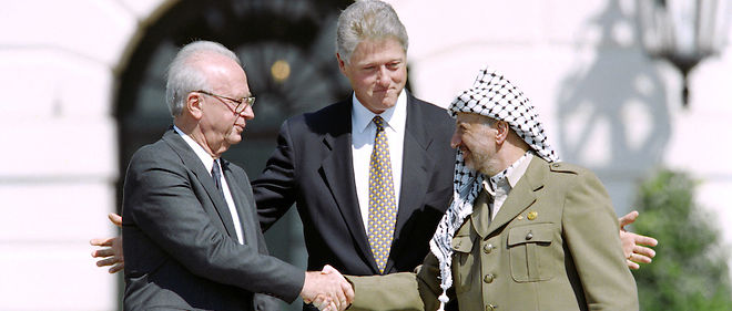 Le 13 septembre 1993, une poignee de main historique a lieu entre Yitzhak Rabin et Yasser Arafat sous les auspices du president americain Bill Clinton. Deux ans plus tard, Arafat ne se rendra pas aux obeques du Premier ministre assassine. 