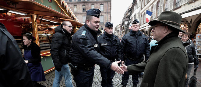 Bernard Cazeneuve salue un policier sur le marche de Noel de Strasbourg. Image d'illustration.