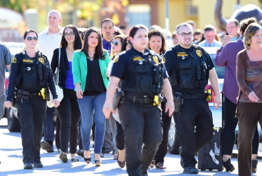 Des policiers escortent des civils aux abords du lieu de la fusillade qui à eu lieu à San Bernardino en Californie, le 2 décembre 2015 © FREDERIC J. BROWN AFP