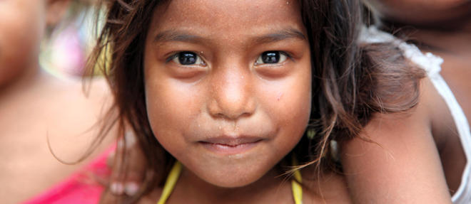 Loin des accords politiques internationaux, des millions d'hommes, de femmes et d'enfants subissent deja les repercutions du changement climatique, comme cette petite fille aux Kiribati.