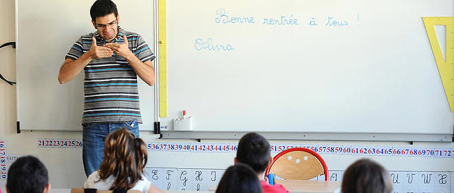 Un professeur utilise le langage des signes devant ses eleves. Image d'illustration.