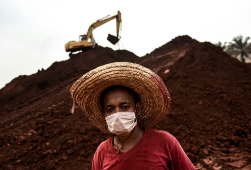 Un ouvrier porte un masque sur son visage, dans une mine de bauxite dans l'état du Pahang en Malaisie, le 13 octobre 2015 © MANAN VATSYAYANA AFP