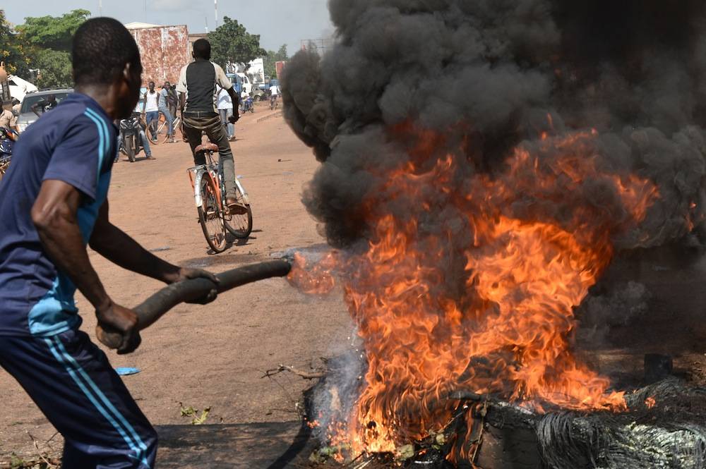 Des manifestants brulent des pneus à Tampouy près de Ouagadougou en signe de protestation contre les décisions de la Cédéao après le coup d'état de Gilbert Diendéré, le 21 septembre 2015. ©  AFP PHOTO / SIA KAMBOU