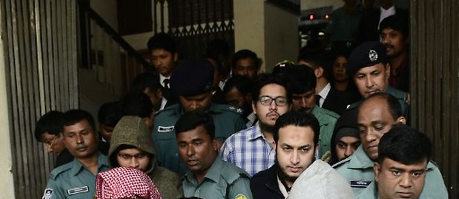 Des policiers escortent certains des accuses dans l'affaire du meurtre d'un blogueur athee, a la sortie du tribunal de Dacca, le 31 decembre 2015