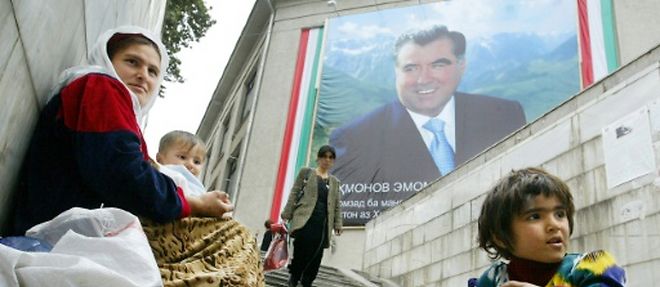 Une mere et ses enfants font la manche dans un passage pietonnier de Douchanbe, devant une affiche du president tadjik Emomali Rakhmonov, le 23 octobre 2006