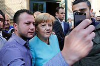 Des refugies posent avec Angela Merkel, le 10 septembre, a Berlin (C)(C) Fabrizio Bensch / Reuters